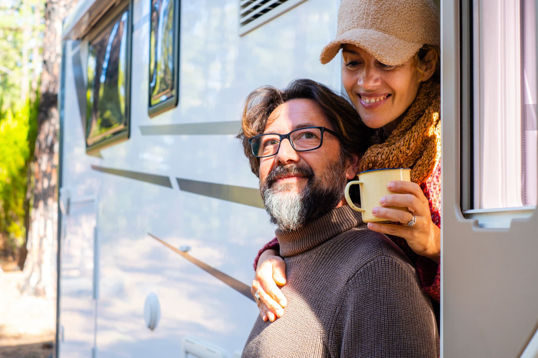Glückliches Paar genießt entspannte Camping-Zeit am Wohnmobil