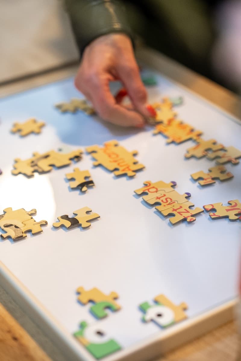 Hände beim Zusammensetzen des Jetzt-Puzzles auf dem Brand Day