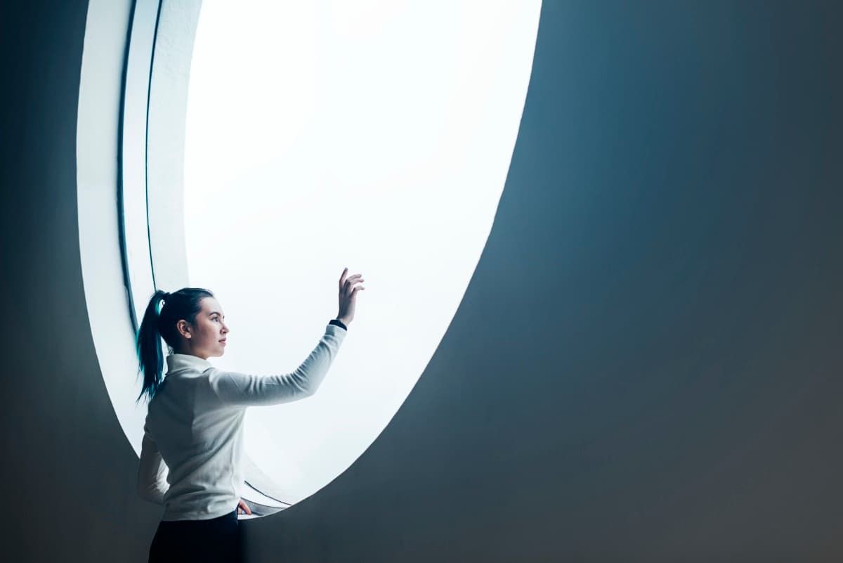 Frau interagiert mit Lichtportal als Metapher für Brand Audit und Markenklarheit