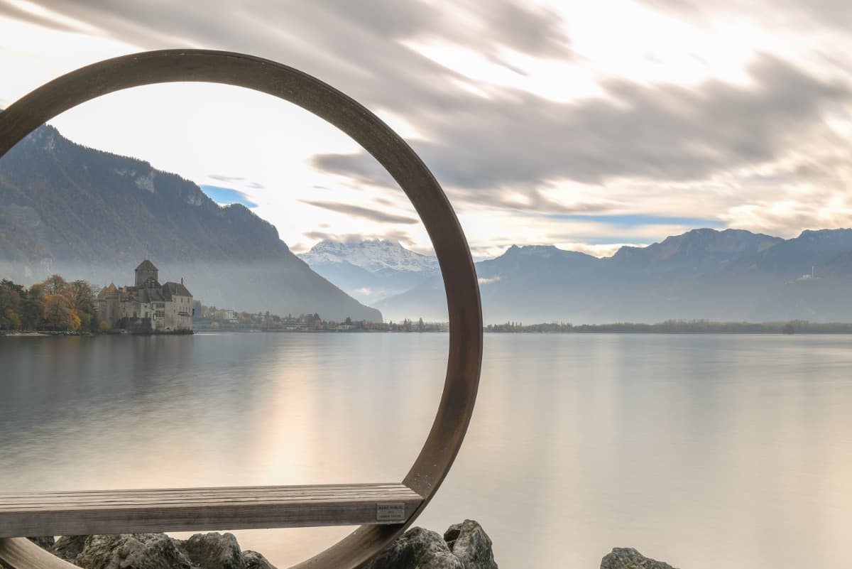 Blick durch einen kreisförmigen Rahmen auf einen See mit Bergen
