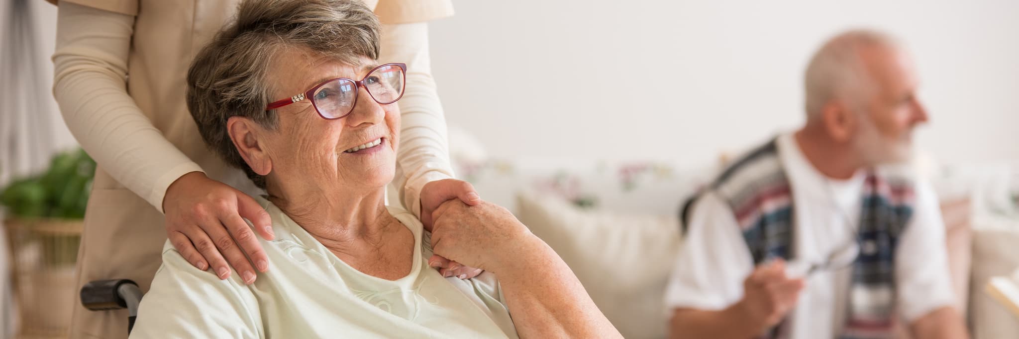 Glückliche Seniorin mit professioneller Pflegekraft