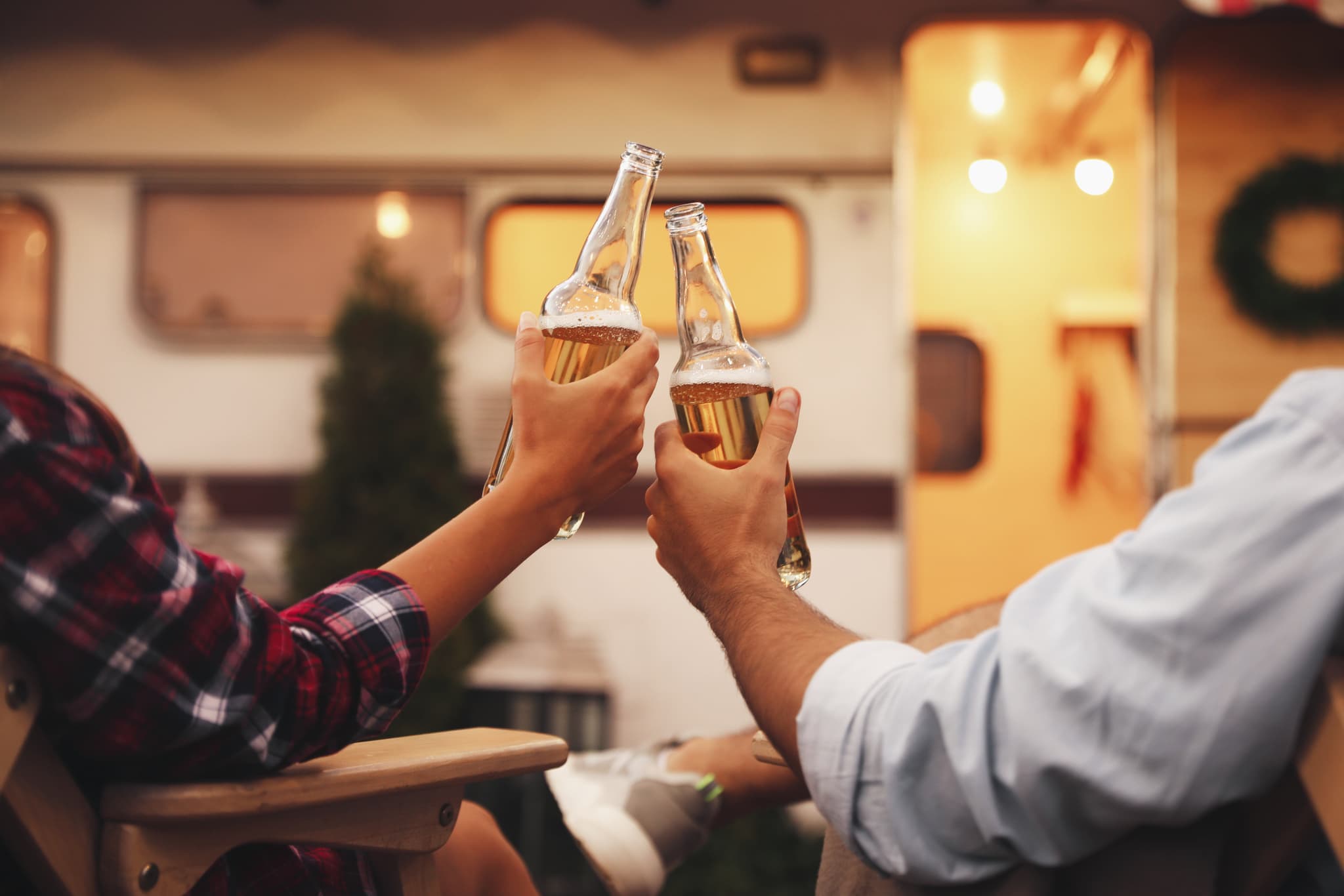 Freunde mit Bier vor Wohnwagen – Community und Markenerlebnis