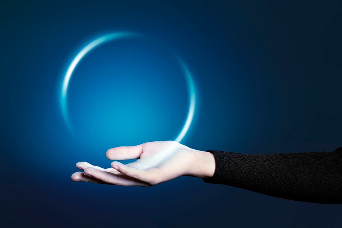 Hand präsentiert schwebendes Lichthologramm als Symbol für klare Kommunikation